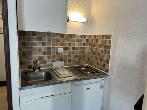 une petite cuisine avec un évier et un évier dans l'établissement Studio Cabine Proche Plage avec Terrasse - Le Grau-du-Roi - FR-1-250-297, au Grau-du-Roi