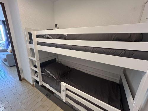 quelques lits superposés dans une chambre dans l'établissement Studio Cabine Proche Plage avec Terrasse - Le Grau-du-Roi - FR-1-250-297, au Grau-du-Roi