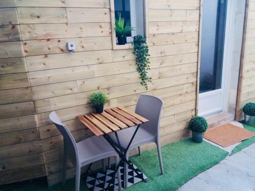 une table et des chaises en bois devant un mur dans l'établissement Maisonnette centre au calme, à Nantes