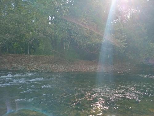 a view of a river with the sun shining at Cabaña de Lucas in Loma Bonita
