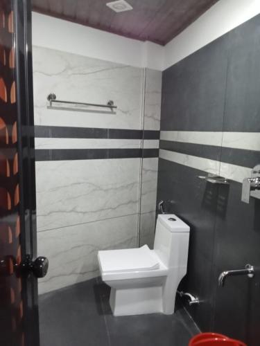 a bathroom with a white toilet in a stall at River View Munnar in Chillithodu