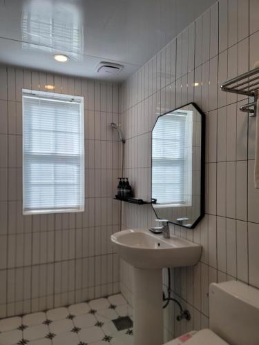 a bathroom with a sink and a mirror at Adellia Pension in Gyeongju