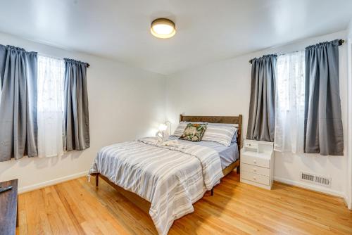 a bedroom with a bed and two windows at 15 Mi to Dtwn Detroit Cozy Family Home with Yard! in Detroit