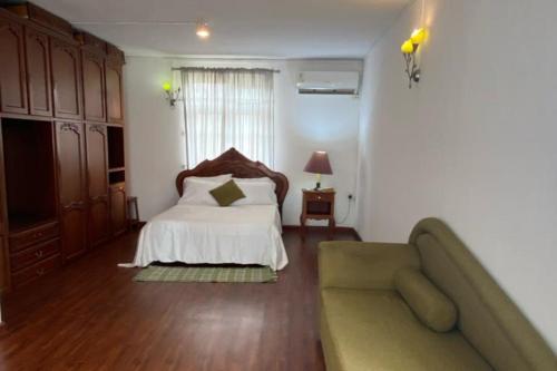 a bedroom with a bed and a couch in it at Le Botanic Oasis 3 beds summer vacation private villa with private pool and garden albion in Albion