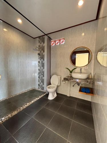a bathroom with a toilet and a sink and a mirror at Ubud Sky in Ubud