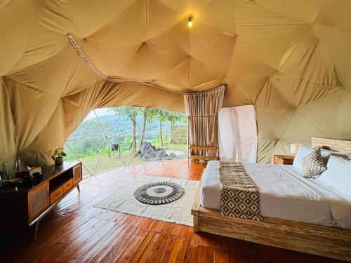 a bedroom with a bed in a tent at De'Ra Hills Camp Kintamani in Kintamani