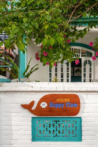 a sign for a house happy clam on a wall at House Happy Clam Hoi An in An Bang