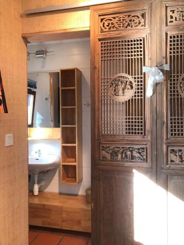 La salle de bains est pourvue d'un lavabo et d'une porte en bois. dans l'établissement House between the sea and the mountain, à San-Giovanni-di-Moriani