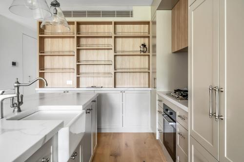 a kitchen with a sink and wooden shelves at Stunning designer 3 Bed 2 bath opp Long Reef Golf Course in Collaroy