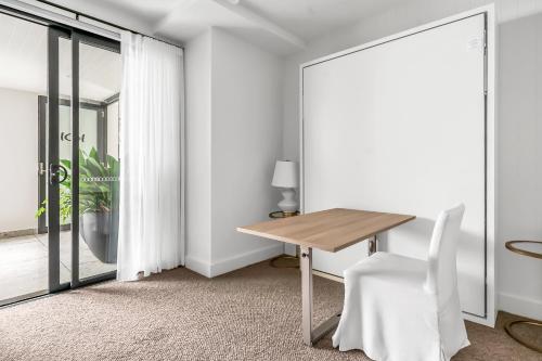 a dining room with a table and a chair at Stunning designer 3 Bed 2 bath opp Long Reef Golf Course in Collaroy
