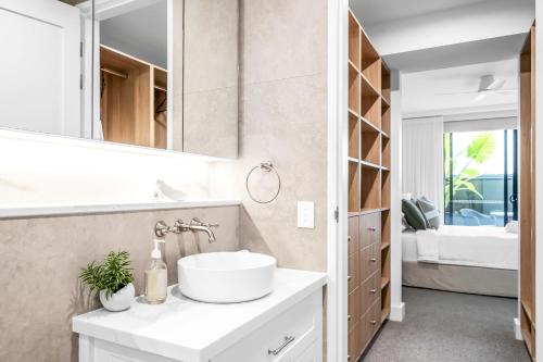 a bathroom with a sink and a mirror at Stunning designer 3 Bed 2 bath opp Long Reef Golf Course in Collaroy