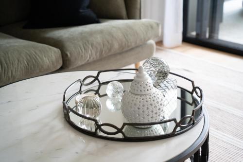a round coffee table with glass items on it at Stunning designer 3 Bed 2 bath opp Long Reef Golf Course in Collaroy