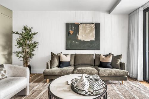 a living room with a couch and a table at Stunning designer 3 Bed 2 bath opp Long Reef Golf Course in Collaroy