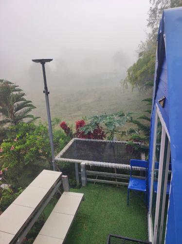 a blue chair sitting on the porch of a house at หนาวกลางหมอกโฮสเตย์ เขาค้อ in Phetchabun