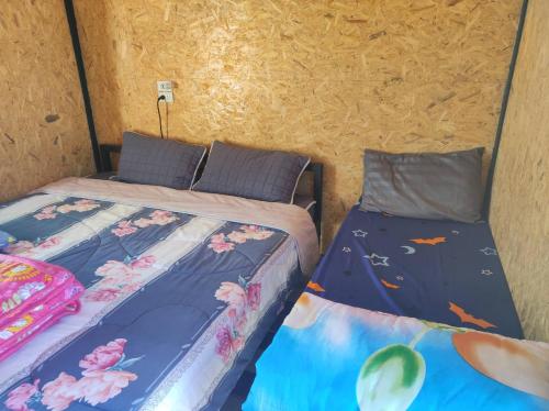two beds sitting next to each other in a room at หนาวกลางหมอกโฮสเตย์ เขาค้อ in Phetchabun