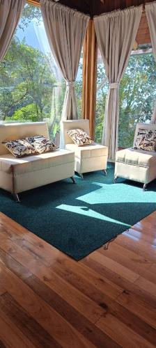 two beds in a room with a large window at La Casa de Martin in Baños