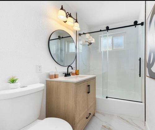 a bathroom with a sink and a toilet and a mirror at Cozy beautiful house in Glendora