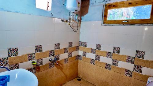 a bathroom with a sink and a window at Rustic Mud House Jibhi in Jibhi
