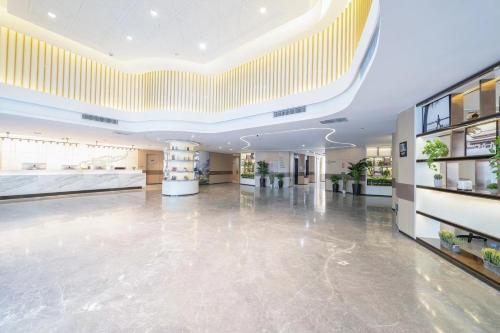 a large lobby with a large ceiling at Atour Hotel Harbin Songbei Sunac Mao in Harbin