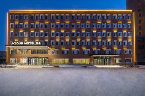 a large building with a sign on the front of it at Atour Hotel Harbin Songbei Sunac Mao in Harbin