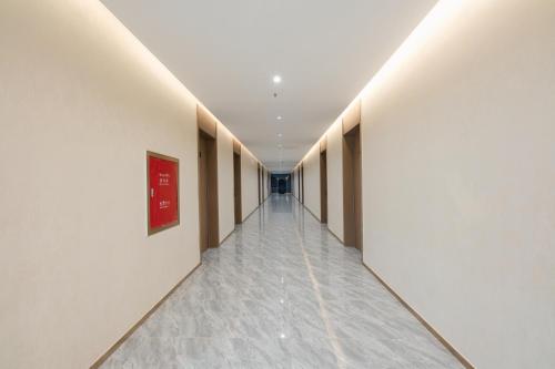 an empty corridor of a building with white walls and a long hallway at 新骏龙酒店 in Phumĭ Bavĕt (2)
