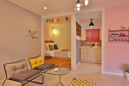 a living room with a couch and a bedroom at Adellia Pension in Gyeongju