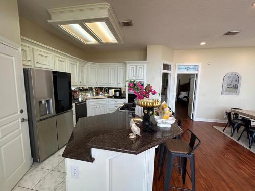 a kitchen with white cabinets and a table with flowers at Stay by Kemah Boardwalk- Diamond Retreat in Kemah