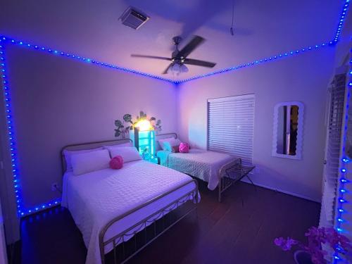 a bedroom with two beds and blue lights at Stay by Kemah Boardwalk- Diamond Retreat in Kemah