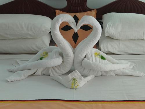 two swans made out of towels on a bed at Lucky Prince Villa in Aluthgama
