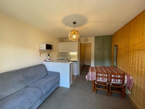 un salon avec un canapé et une table et une cuisine dans l'établissement Charmant Studio avec Balcon et Parking à Barcelonnette - FR-1-804-50, à Barcelonnette