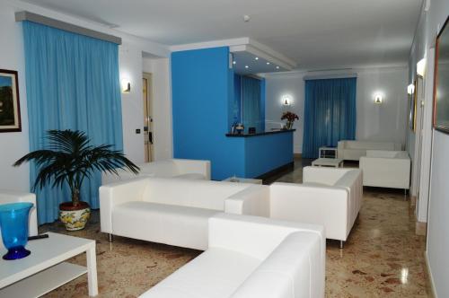 a living room with white couches and a blue wall at Delfino in Marina di Camerota