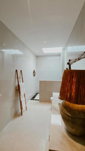 a room with a wooden bowl and a chair at Villa Hope Bali in Kerobokan