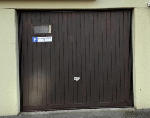 a wooden garage door with a parking sign on it at Feel Home Apartments 501 - Seeblick - Bergblick - Parkplatz in Emmetten