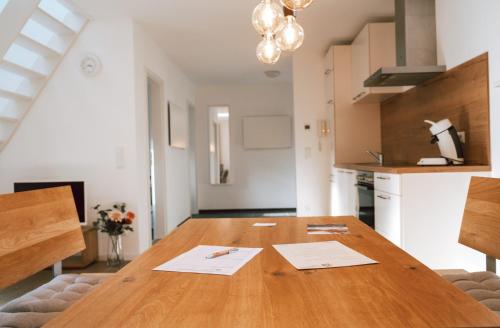 a kitchen with a wooden table with papers on it at Frankenwald Chalets - Ferienhaus mit privaten Whirlpool in Wilhelmsthal