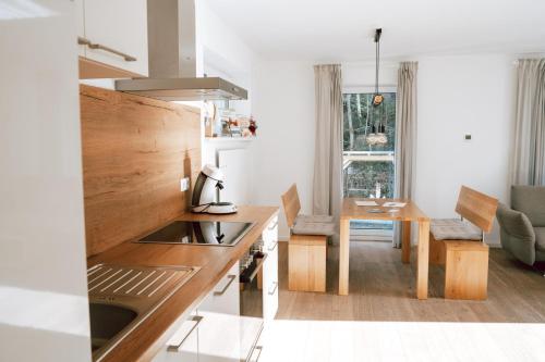 a kitchen with a sink and a table in a room at Frankenwald Chalets - Ferienhaus mit privaten Whirlpool in Wilhelmsthal