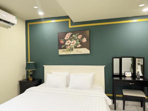 a bedroom with a white bed and a desk with a mirror at La Casona Hotel in Ho Chi Minh City