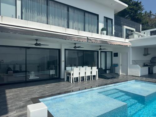 a villa with a swimming pool and a house at Balcony on the sea in Amphoe Koh Samui