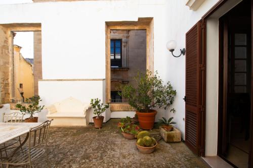 a courtyard with potted plants and an open door at Palazzo Insula in Gallipoli