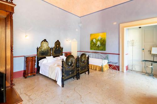 a bedroom with two beds and a painting on the wall at Palazzo Insula in Gallipoli