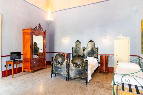 una camera da letto con un letto, un tavolo e uno specchio di Palazzo Insula a Gallipoli