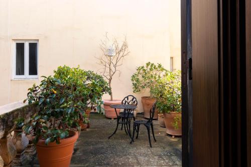 a patio with potted plants and a table and chairs at Palazzo Insula in Gallipoli
