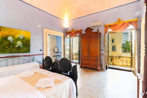 a bedroom with two beds and a large window at Palazzo Insula in Gallipoli