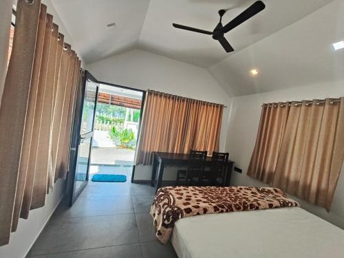 a bedroom with a bed and a ceiling fan at ART Marari Beach house in Mararikulam