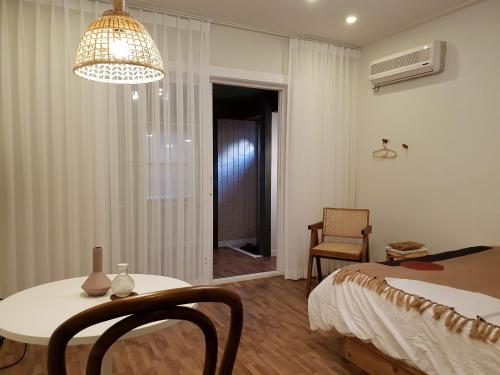 a bedroom with a bed and a table and a chandelier at Adellia Pension in Gyeongju