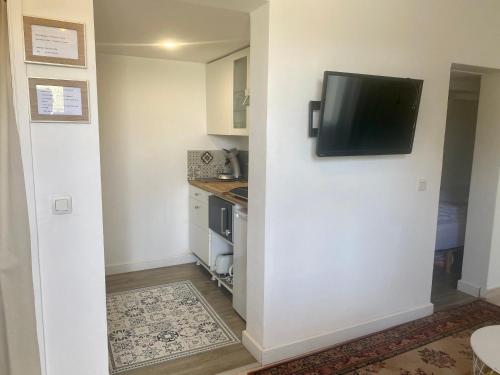 a small kitchen with a tv on a wall at Au pied du luberon in Pertuis