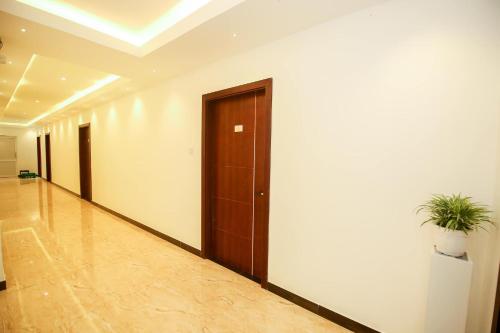 a hallway with a door and a potted plant at Ruish City Hotel Kandy in Kandy
