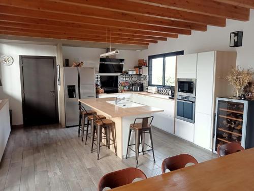 une cuisine avec une table et quelques chaises dans l'établissement Loft avec piscine et spa, à Cérans-Foulletourte