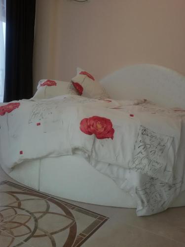 a white bed with red roses on it at Sandanski Peak Guest Rooms in Sandanski