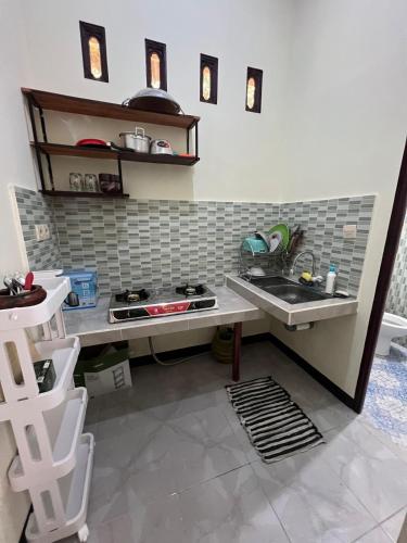 a small kitchen with a sink and a stove at Parkside nest-studio 3 in Kuta Lombok