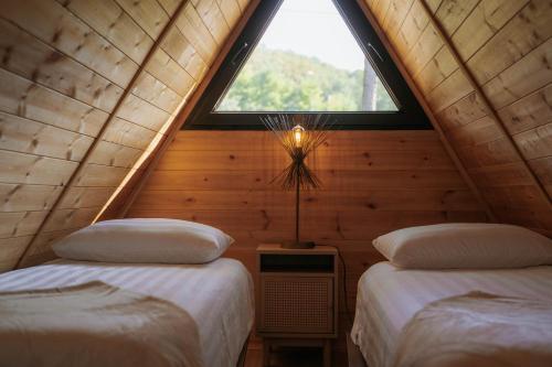 a attic bedroom with two beds and a window at Ikalto Woods in Tʼelavi